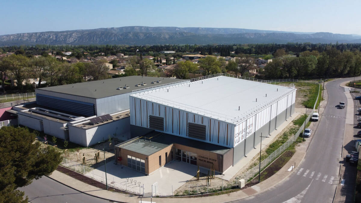 Construction d'un gymnase à Sénas. Un bâtiment durable en bois, dédié à la pratique du basket et du handball.