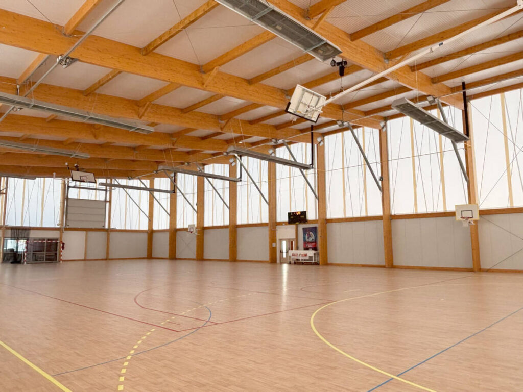 Construction d'un gymnase à Sénas. Un bâtiment durable en bois, dédié à la pratique du basket et du handball.